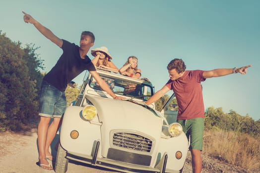Vintage style image of boys with a map fighting over directions, and girls waiting in the car.