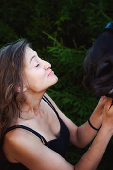Emotional  Portrait of a female in love with horses, black Friesian stallion thoroughbred pet, outdoors.
