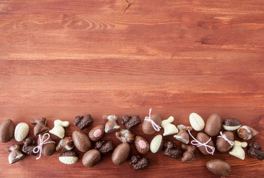 Various chocolates and Easter eggs at Easter on a wooden background
