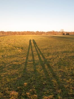 two human silhouettes large legs field of grass background  essex  england  uk