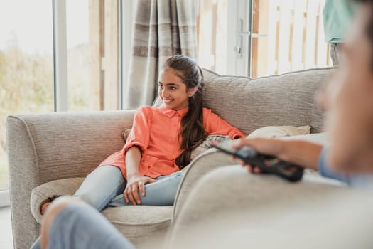 Female teenager relaxing on vacation, sitting on the sofa and laughing.