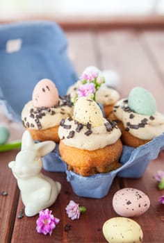 Small cupcake with Easter eggs in cardboard box for Easter