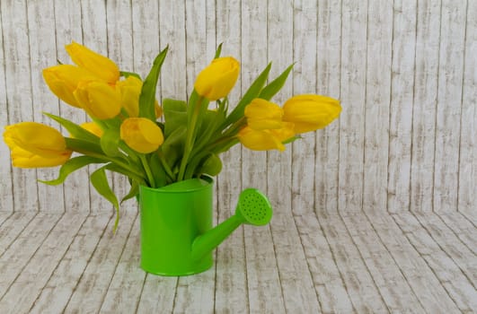 Yellow tulips in a vase on background with structure