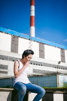 young woman dressed in white sneakers, a T-shirt and blue jeans, against the backdrop of cityscapes. Street fashion