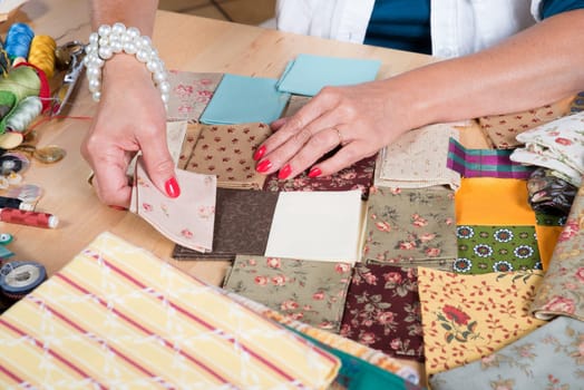 Close up of woman's hand sewing patchwork