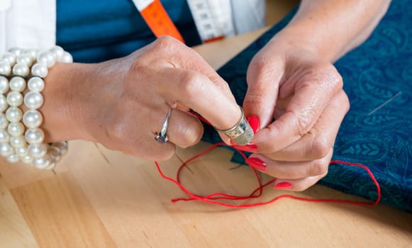 a woman threader the wire in a needle