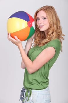 Female teenager holding inflatable beach ball