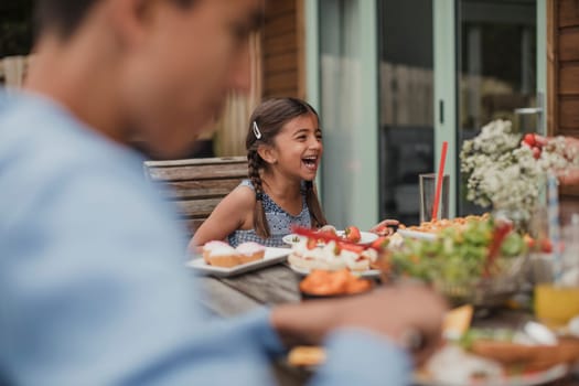 Little girl laughing at the table during brunch.