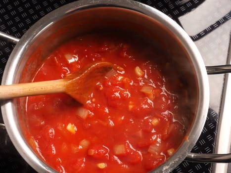Cooking tasty tomato sauce with garlic onions and spicy herbs