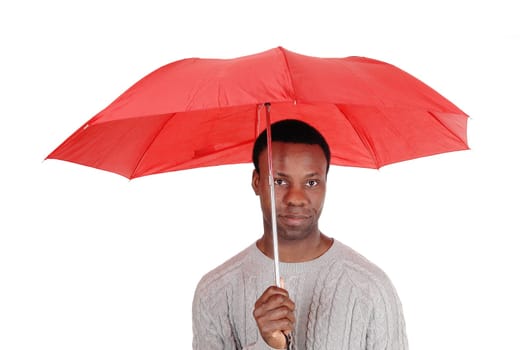 A closeup image of a African man standing from the front and holding.a red umbrella over his head, isolated for white background.