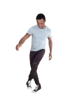 A handsome young African American man in a gray polo shirt and track.pants dancing all by himself, isolated for white background.