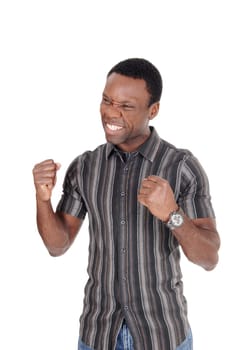A young handsome African American man standing in a striped shirt with.his fists and smiling of victory and success, isolated over white.