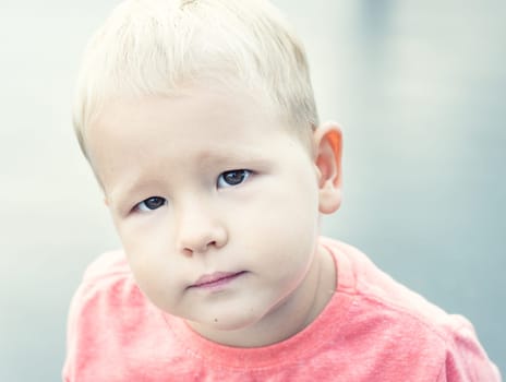 Boy lookind at camera. High key portrait