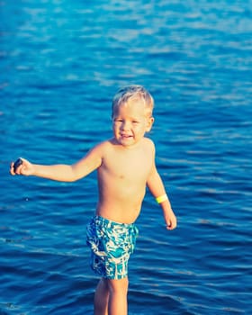 Cute boy plays in a sea