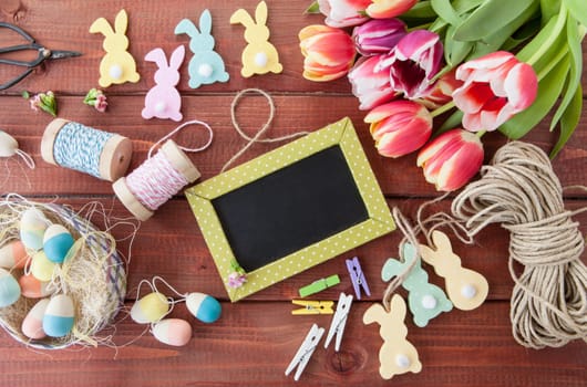 Colorful Easter decoration and tulips rustic background made of wood