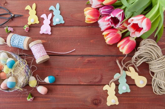 Colorful Easter decoration and tulips rustic background made of wood