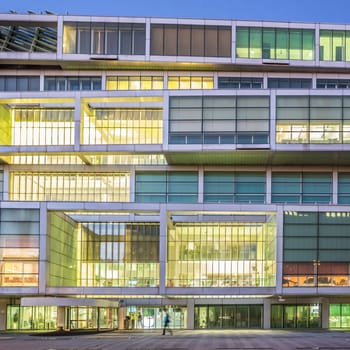 Contemporary architectural exterior of Slovenian Chamber of Commerce shot at dusk.