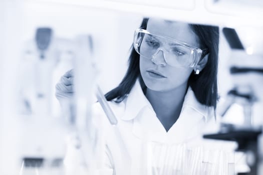 Scientists researching in scientific laboratory. Young female young PhD student scientist researching in the life science research laboratory. Biochemistry, genetics, forensics, microbiology ..