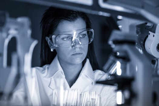 Scientists researching in scientific laboratory. Young female young PhD student scientist researching in the life science research laboratory. Biochemistry, genetics, forensics, microbiology ..