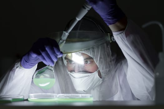 Life scientist researching in bio hazard laboratory. Focused life science professional working on experiment in high protection degree work laboratory. Healthcare and biotechnology.