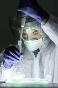 Life scientist researching in bio hazard laboratory. Focused life science professional working on experiment in high protection degree work laboratory. Healthcare and biotechnology.