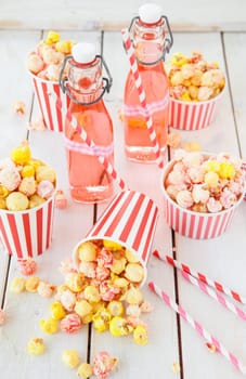 Colorful popcorn in striped cups and lemonade in small faschen