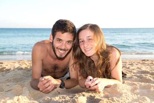 Happy young couple posing in the beach