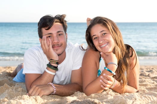 Happy teenage couple posing in the beach
