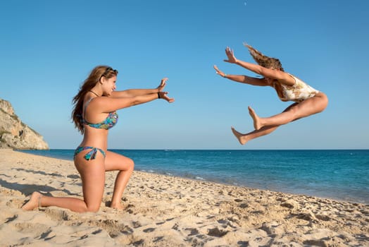 Two girls playing and having fun at the beach.