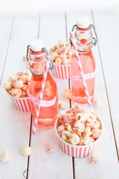 Colorful popcorn in striped cups and lemonade in small faschen