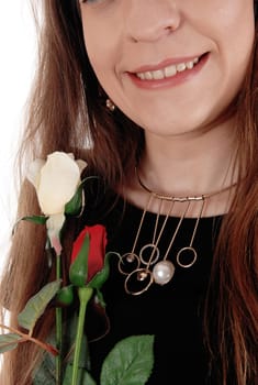 A closeup image of the necklace and mouth of a young woman holding.two roses, with long hair and black dress, isolated over white.