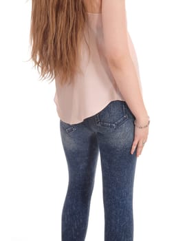 A close up image of the legs and butt of a young woman in jeans.and pink blouse standing isolated for white background.