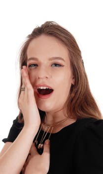 A close up image of a young woman telling a secret behind her hand,.in a black dress and necklace, isolate for white background.