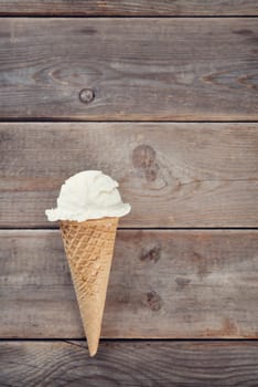 Top view yogurt ice cream wafer cone on rustic wooden background.