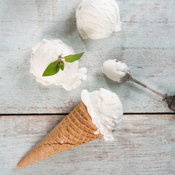 Top view vanilla ice cream wafer cone on white rustic wooden background.