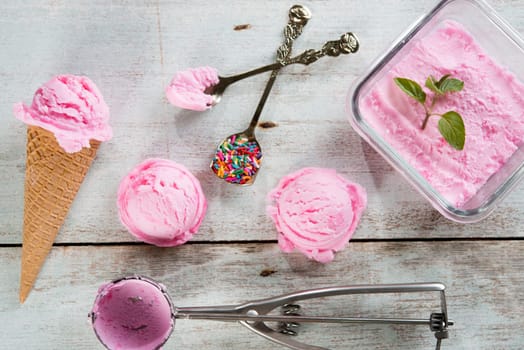 Top view pink ice cream waffle cone on wooden background.