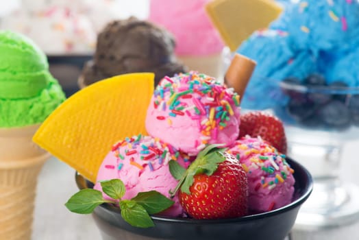 Pink ice cream in bowl with strawberry fruits and waffle close up.