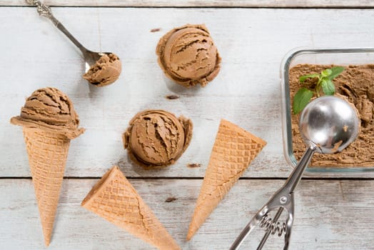 Top view brown ice cream in waffle cone on old rustic vintage wooden background.