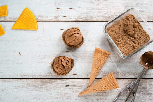 Top view brown ice cream with waffle cone on old rustic vintage wooden background.