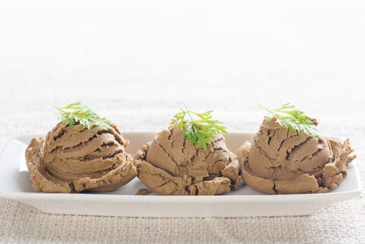 Brown ice cream in plate on dining table with copy space.