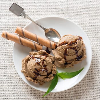 Top view plate of chocolate ice cream with syrup on dining table.
