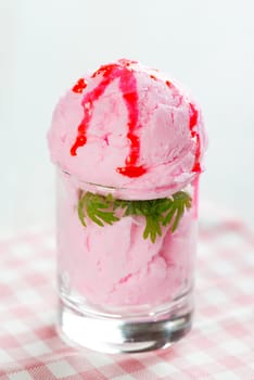Strawberry ice cream cup on white wooden background.