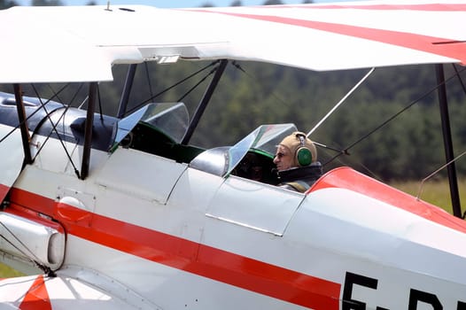 Pilot of a biplane happy after landing on the Mende airfield in the French department of Gard