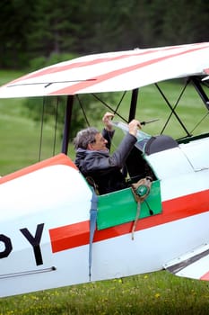 Pilot of a biplane happy after landing on the Mende airfield in the French department of Gard
