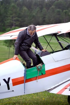 Pilot of a biplane happy after landing on the Mende airfield in the French department of Gard
