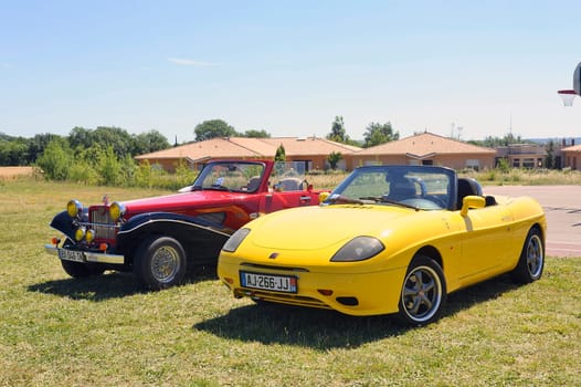 yellow Fiat convertible shown in a vintage car rally