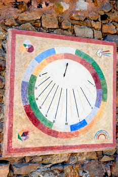 a modern and colorful sundial on a wall