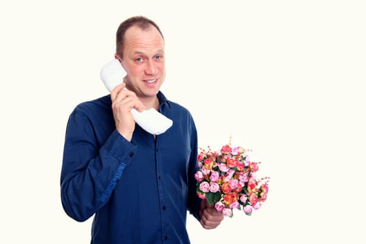 young man with bunch of flowers calling in front of white background