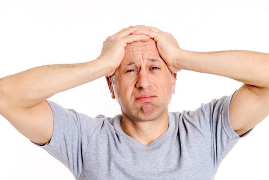young man with hands on head looking shocked