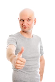 young man with bald head and thumb up is looking friendly in to the camera